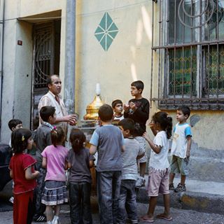Photo by: @renaeffendiphoto Children waiting for sweet treats from a street vendor in Tarlabasi a multicultural neighborhood home to Istanbul's diverse communities of Anatolian migrants, Roma, transgender and now Syrian refugees of mainly Gypsy background from Dom. Follow @renaeffendiphoto for human interest stories #istanbul #turkey #streetphotography #streetlife #neighborhood #icecream #sweets #children #culture